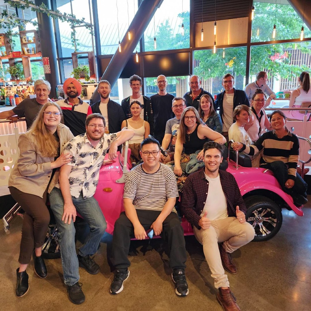 Lentune team members gathered around a retro car for a group photo.