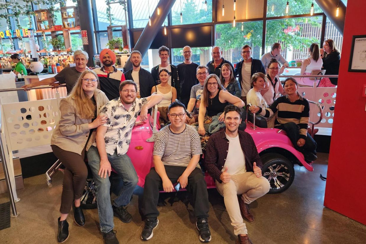 Lentune team has gathered for a group photo around a retro car
