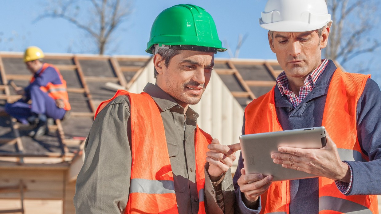 Project managers on a tablet at a construction site